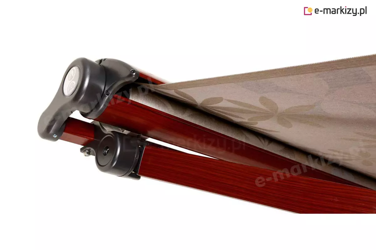 Markiza w półkasecie Adagio MOL. Do drewnopodobnej (obecnie kolorystyka niedostępna) aluminiowej kasety zwijana jest cała tkanina poszycia w kolorze kremowo-brązowym z tłoczonym wzorem w duże kwiaty, natomiast ramiona po złożeniu pozostają widoczne pod kasetą. Elementy łącznikowe wykonane z pcv oraz aluminium wykonano w kolorze czarnym. Lewy bok markizy przedstawiono na białym tle.