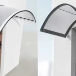 Grafika składa się z dwóch kadrów prezentujących łukowate daszki naddrzwiowe zamontowane nad wejściami do budynków, ukazujące różne warianty kolorystyczne profili przy zachowaniu tego samego typu wypełnienia. Konstrukcje charakteryzują się łagodnym wygięciem w górę oraz rynienkami odpływowymi zintegrowanymi z przednią krawędzią profilu. Wypełnienie obu daszków stanowi przezroczysta płyta o gładkiej powierzchni, która przepuszcza dużą ilość światła dziennego. Lewe zdjęcie przedstawia daszek w wersji z białymi profilami aluminiowymi. Konstrukcja jest zamontowana do jasnej elewacji, a pod nią widoczny jest fragment brązowych drzwi wejściowych z czarną klamką i podłużnym przeszkleniem. Perspektywa z boku pozwala dostrzec smukłość białej ramy oraz sposób, w jaki daszek osłania strefę progu. Prawe zdjęcie ukazuje ten sam model daszka, ale w wersji z profilami w kolorze ciemnoantracytowym lub czarnym. Zadaszenie zamontowane jest nad wnęką drzwiową w białej ścianie budynku. Widoczny pod kątem daszek posiada poprzeczną czarną listwę wzmacniającą, która biegnie wzdłuż łuku, stabilizując przezroczyste wypełnienie. W tle, pod zadaszeniem, widać górną część nowoczesnych drzwi w kolorze jasnego drewna z pionowym, szklanym elementem.