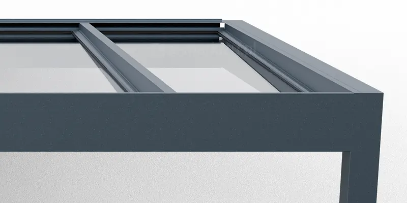 Prosta konstrukcja aluminiowego zadaszenia Spekta Glass z widocznymi krokwiami wewnętrznymi. W konstrukcji w kolorze antracytowym zamocowane są pod kątem tafle przejrzystego szkła.