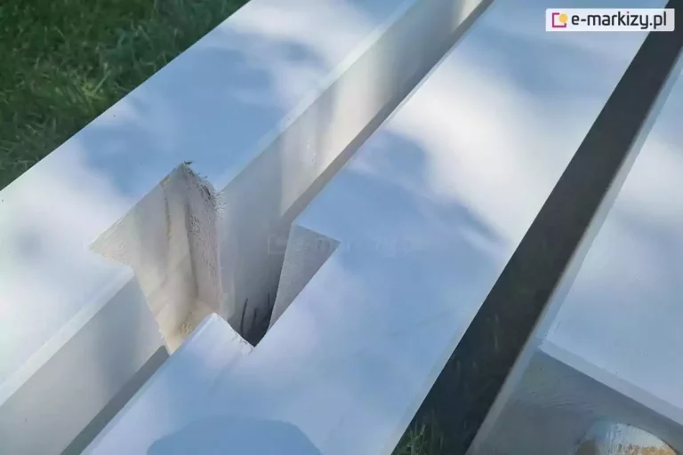 Belki pergoli drewnianej Moza z charakterystycznymi nacięciami do mocowania bramki pergoli, ułożone na trawie.