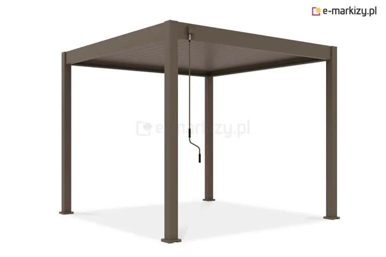 Zdjęcie przedstawia wolnostojącą pergolę tarasową Marlo w kolorze taupe, wykonaną z wysokiej jakości aluminium o matowym wykończeniu. Konstrukcja opiera się na czterech solidnych, pionowych słupach o kwadratowym profilu, które podtrzymują płaski dach lamelowy. Pióra zadaszenia są całkowicie zamknięte, tworząc jednolitą, horyzontalną osłonę przed słońcem i deszczem. Na jednym z przednich słupów zamontowany jest manualny mechanizm korbowy z długim drążkiem, który służy do płynnej regulacji kąta nachylenia lameli. Całość charakteryzuje się nowoczesnym, minimalistycznym designem, a słupy zakończone są kwadratowymi stopami montażowymi, ułatwiającymi stabilne przytwierdzenie konstrukcji do podłoża. Produkt jest wyeksponowany na neutralnym, białym tle, co pozwala na dokładną ocenę formy i koloru pergoli.