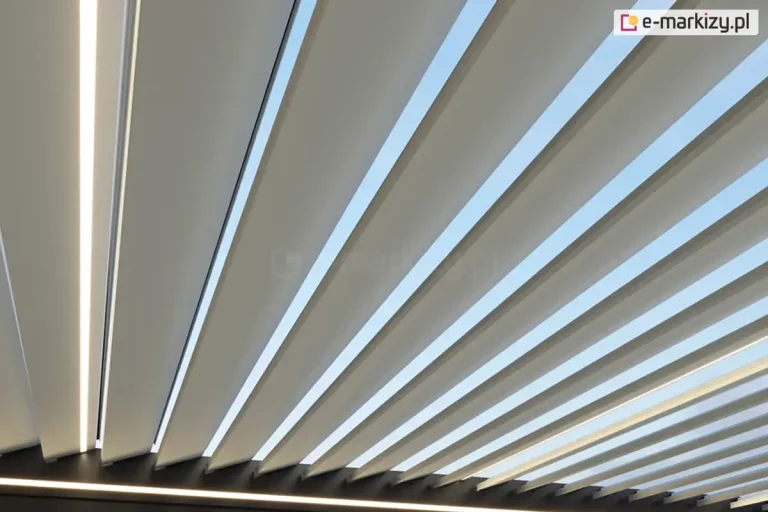 Lekko uchylone lamele pergoli Marlo w kolorze białym z widocznym pomiędzy nimi błękitnym niebem. Lamele zamocowane w antracytowej konstrukcji z oświetleniem LED w postaci taśmy wzdłuż zintegrowanych rynien pergoli.