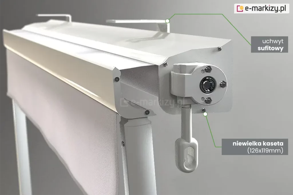 Zbliżenie konstrukcji markizy Italia kasetowa z napędem ręcznym w kolorze białym z białym poszyciem. Widoczna od prawego boku kaseta z lekko wysunięta belką przednią i umocowanym w niej ramieniem. Do boku kasety przymocowana przekładnia korbowa z zaczepem do sterowania ręcznego za pomocą korby. W tle nad kasetą widoczne mocowania do sufitu. Od prawego mocowania oznaczonego okrągłym znacznikiem poprowadzono w prawo zieloną kreskę do umieszczonego na szarym tle napisu "uchwyt sufitowy". Poniżej, od brzegu kasety, na której skraju umieszczono okrągły znacznik poprowadzono w dół i na prawo kreskę do umieszczonego na szarym tle napisu "niewielka kaseta (126x119mm)".