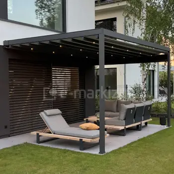 Nowoczesna kwadratowa pergola tarasowa Square Flat z antracytową konstrukcją aluminiową i dachem z tkaniny napinanej, zamontowana przy elewacji domu z żaluzjami fasadowymi, wyposażona w oświetlenie LED i eleganckie meble ogrodowe – leżanki i narożnik na trawniku.