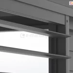 Zbliżenie techniczne na system ruchomych lameli bocznych pergoli Gloria w kolorze ciemnoantracytowym. Zdjęcie przedstawia detale konstrukcyjne dwóch sąsiadujących sekcji paneli: po lewej stronie widoczne są trzy poziome lamele ustawione w pozycji otwartej (poziomej), ukazujące ich płaski, aerodynamiczny profil oraz mechanizm mocowania do pionowej ramy. Po prawej stronie znajduje się fragment panelu z lamelami w pozycji zamkniętej, które nachodzą na siebie, tworząc jednolitą, nieprzezierną płaszczyznę. W górnej części widoczna jest masywna, pozioma belka ramy głównej z precyzyjnym wykończeniem krawędzi, a całość prezentuje matową strukturę lakierowanej powłoki aluminiowej.