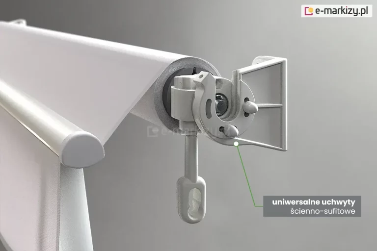 Zbliżenie techniczne na system mocowania markizy balkonowej Italia, prezentujące uniwersalne uchwyty ścienno-sufitowe. Na zdjęciu widoczna jest boczna głowica markizy w kolorze jasnoszarym, zamontowana w odlewanym, aluminiowym uchwycie o budowie modułowej. Konstrukcja uchwytu posiada prostopadłe płaszczyzny z otworami, co pozwala na jego przykręcenie zarówno do pionowej ściany, jak i poziomego sufitu. W centralnej części detalu widoczna jest przekładnia z wyciągniętym pionowo w dół plastikowym uchem, służącym do obsługi za pomocą korby. Belka nawojowa z nawiniętą jasną tkaniną jest stabilnie osadzona w gnieździe uchwytu. Po prawej stronie u dołu znajduje się szary prostokąt z białym napisem informacyjnym, od którego zielona linia prowadzi do punktu styku głowicy z uchwytem, podkreślając precyzję dopasowania elementów. W tle widoczna jest również przednia belka obciążająca z zaokrągloną zaślepką boczną.