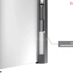 Przekrój techniczny pionowego profilu markizy bocznej Bora, prezentujący wewnętrzny system napędowy. Na zbliżeniu widoczny jest wysokiej jakości mechanizm sprężynowy umieszczony wewnątrz ciemnoszarej, aluminiowej kasety. Stalowa sprężyna naciągowa o gęstym splocie jest zamontowana pionowo na prowadnicy, odpowiadając za automatyczne zwijanie białego materiału markizy. Tkanina jest częściowo wysunięta i zamocowana do ruchomego, pionowego słupka z uchwytem, który spoczywa na okrągłej stopie montażowej przytwierdzonej do podłoża. Po prawej stronie zdjęcia znajduje się szary prostokąt z białym napisem informacyjnym w języku polskim, od którego odchodzi linia wskazująca bezpośrednio na detal sprężyny.