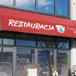 Markiza koszowa prosta z poszyciem i prostą falbaną w kolorze czerwonym z wykonanym na polu nad falbaną dużym nadrukiem reklamowym z logo restauracji oraz napisami "Restauracja po lewej" i "pyszna pizza", umieszczona na fasadzie nowoczesnego budynku z dużym oknem tworzącym wejście do restauracji.