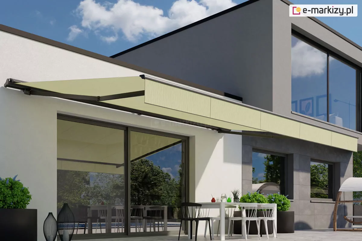Zdjęcie przedstawia nowoczesną wizualizację dwupoziomowego budynku o minimalistycznej architekturze, na którym zamontowano szeroką markizę Adagio. Markiza posiada poszycie w jednolitym, jasnooliwkowym lub beżowym kolorze, które idealnie komponuje się z białą i szarą elewacją domu. Konstrukcja wsporcza, w tym ramiona przegubowe oraz profil frontowy, została wykonana w kontrastowym, ciemnografitowym kolorze. Markiza Adagio jest w pełni rozwinięta, osłaniając przestronny taras przed intensywnym światłem słonecznym. Pod zadaszeniem znajduje się strefa wypoczynkowa z nowoczesnym, białym stołem i dopasowanymi krzesłami, przy którym stoją kolorowe szklanki. Na tarasie widoczne są również duże, ciemne donice z zieloną roślinnością oraz dekoracyjne lampiony. Przeszklenia parteru są duże i odbijają otaczającą zieleń ogrodu. Górna kondygnacja budynku wykończona jest szarymi panelami elewacyjnymi i posiada wielkoformatowe okna. Całość sceny dopełnia bezchmurne, błękitne niebo z delikatnymi, białymi chmurami, podkreślając letni, wypoczynkowy charakter miejsca z wykorzystaniem markizy Adagio.