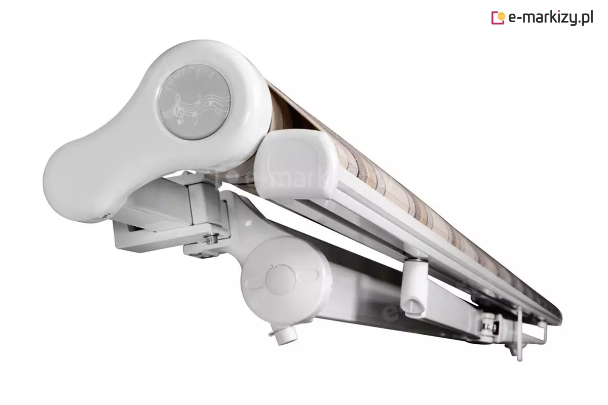 Zdjęcie prezentuje na białym tle produkt, którym jest markiza Mezzo w pozycji złożonej, ukazaną z perspektywy bocznej pod kątem. Aluminiowy stelaż w kolorze białym składa się z dekoracyjnej bocznej pokrywy rury nawojowej z subtelnym wzorem graficznym, belki frontowej oraz złożonych ramion przegubowych. Pomiędzy profilami widoczny jest zwinięty materiał poszycia w pasy o beżowej kolorystyce. Konstrukcja wsparta jest na solidnym uchwycie montażowym z widocznymi śrubami regulacyjnymi, co podkreśla stabilność i wysoką jakość wykonania mechanizmu. Całość tworzy zwartą i estetyczną formę, która po złożeniu zajmuje minimalną ilość miejsca na elewacji.