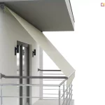 Wizualizacja architektoniczna przedstawia praktyczne zastosowanie produktu, jakim jest markiza balkonowo sklepowa, zamontowana na nowoczesnym balkonie. Osłona została zainstalowana pod betonowym zadaszeniem (sufitem) balkonu za pomocą górnych uchwytów, z których po lewej stronie widoczny jest mechanizm korbowy z uchem do sterowania ręcznego. Jasnobeżowa, gładka tkanina poszycia rozwija się pod skosem, tworząc skuteczną barierę przeciwsłoneczną dla przeszklonych drzwi balkonowych. Dolna belka obciążająca materiał jest wsparta na dwóch poziomych, grafitowych ramionach bocznych, które są przytwierdzone bezpośrednio do bocznych ścian wnęki balkonowej nad chromowaną barierką. Całość kompozycji na tle jasnej elewacji i minimalistycznych czarnych kinkietów podkreśla funkcjonalność markizy w aranżacji przestrzeni wypoczynkowej, chroniąc wnętrze przed nagrzewaniem przy jednoczesnym zachowaniu estetyki budynku.