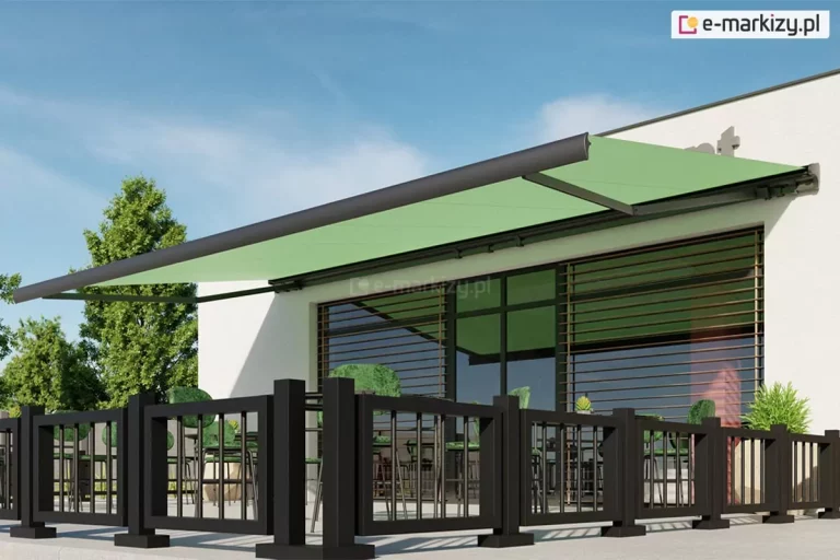 Zdjęcie prezentuje wizualizację nowoczesnego tarasu komercyjnego, na przykład przy kawiarni lub restauracji, osłoniętego dużą markizą tarasową Palladio w pełnym rozłożeniu. Poszycie markizy wykonane jest z gładkiej tkaniny w kolorze jasnej, pastelowej zieleni, która kontrastuje z ciemnoantracytową konstrukcją ramion i całej konstrukcji. Markiza jest zamontowana do białej elewacji budynku, tuż nad dużymi przeszkleniami ujętymi w czarne ramy z poziomymi szprosami. Taras został wydzielony eleganckim, niskim ogrodzeniem w formie czarnej balustrady o geometrycznym kształcie, składającej się z kwadratowych słupków i pionowych szczebli. Wewnątrz strefy wypoczynkowej widoczne są stoliki oraz krzesła z zielonymi obiciami, które kolorystycznie nawiązują do zadaszenia. Po bokach tarasu ustawiono dekoracyjne rośliny w donicach. Całość przedstawiona jest w pełnym słońcu na tle bezchmurnego, błękitnego nieba oraz soczystej zieleni drzew, co podkreśla letni i wypoczynkowy charakter aranżacji.
