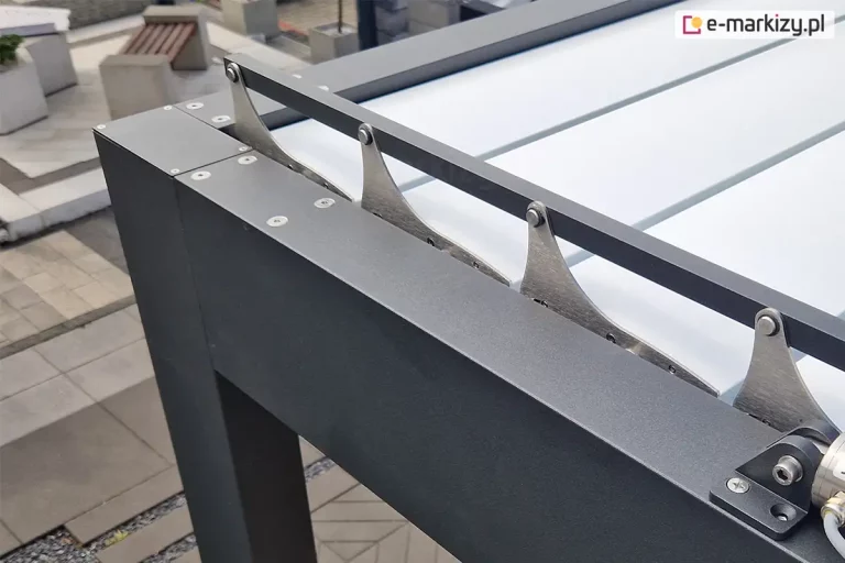 Zbliżenie narożnika konstrukcji pergoli tarasowej SB400 Selt z widocznym mechanizmem regulacji ustawienia paneli dachu tworzących wodoodporne, szczelne zadaszenie.