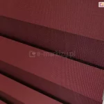 Zbliżenie tkaniny dzień i noc do rolet. Wyraźnie widoczne dwie warstwy tkaniny z ułożonymi naprzemiennie pasami w kolorze bordo oraz przejrzystym. Odpowiednie ustawienie pasów tkaniny zapewnia pełne zakrycie szyby. Po prawej widoczny łańcuszek do sterowania roletką w kolorze białym.