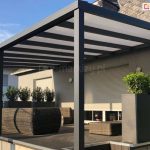 Podwyższony, drewniany taras pod dachem z poliwęglanem komorowym