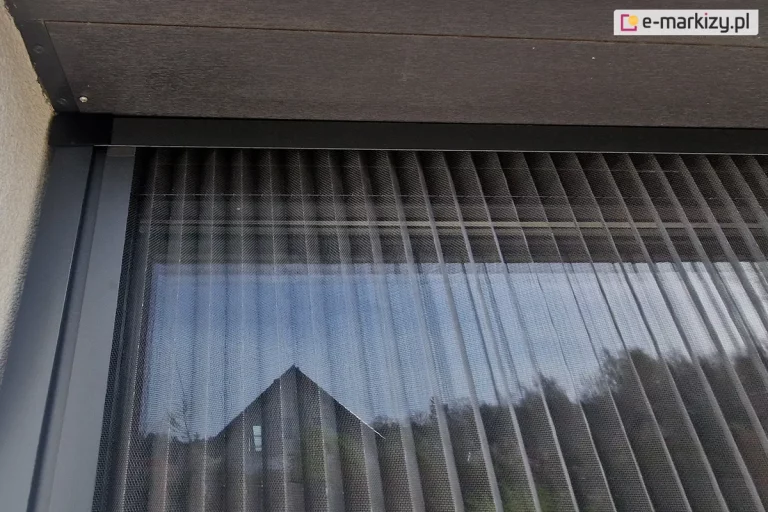 Moskitiera plisowana na oknie tarasowym zamocowana we wnęce pod klapą rewizyjną rolety zewnętrznej.