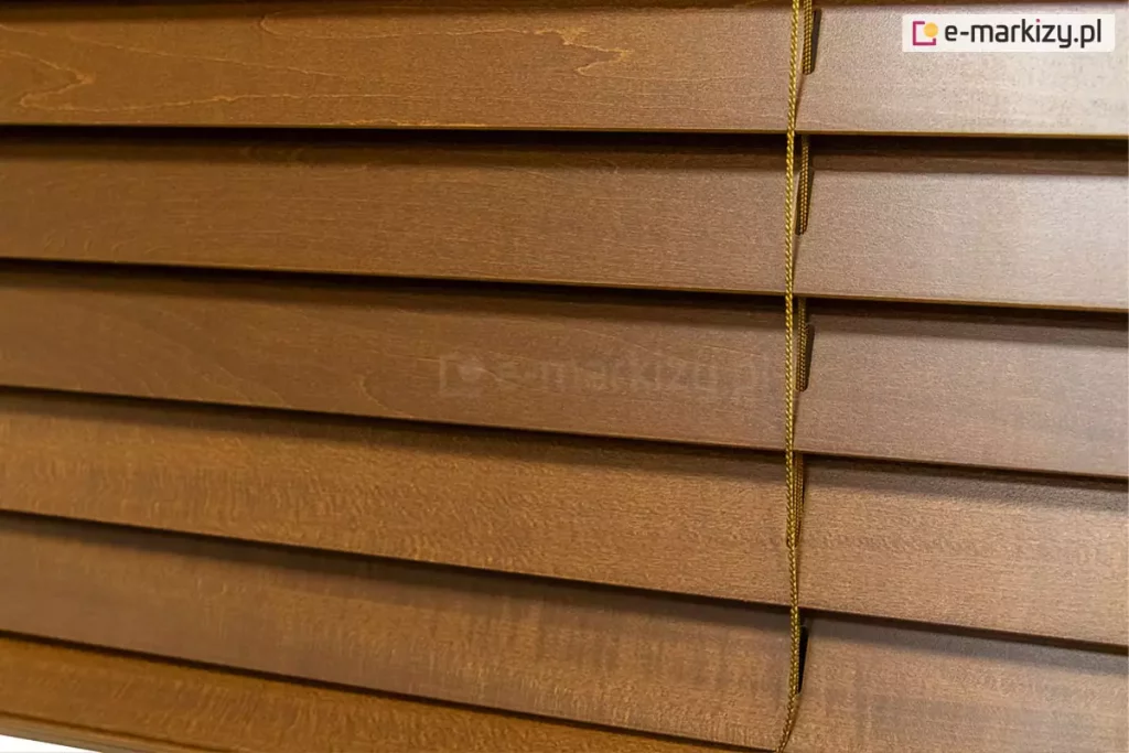 Żaluzja drewniana 25 mm wyposażona w lamele wykonane z naturalnego drewna pokryte bejcą tworzą estetyczną osłonę na okno. Drabinka sznurkowa dobrana jest zawsze pod kolor lameli.