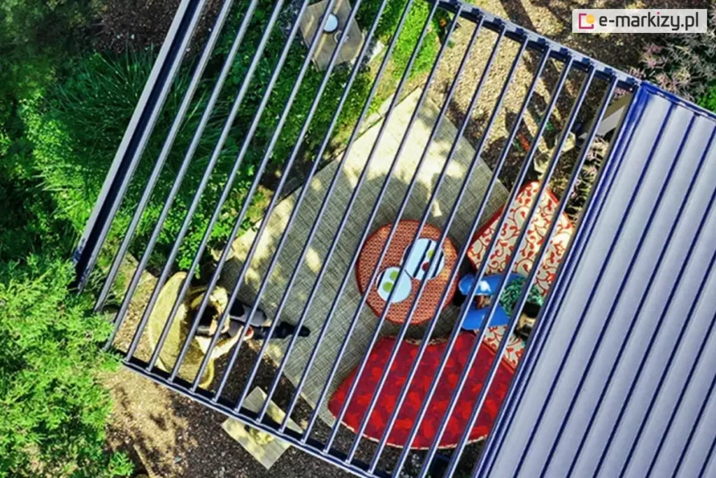 Pergola Gloria w dużym wymiarze z dwoma sterowanymi niezależnie sekcjami dachu lamelowego. Pod pergolą z otwartymi lamelami widoczne patio ogrodowe z melbami i stolikiem, przy którym siedzą dwie osoby oraz zadbany zielony ogród. Dach po prawej stronie posiada zamknięte lamele.