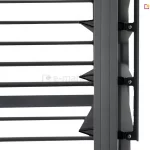 Zbliżenie na techniczny detal konstrukcyjny ruchomych lameli bocznego panelu żaluzjowego do pergoli tarasowej w kolorze antracytowym. Na zdjęciu widoczny jest pionowy profil ramy, do którego zamocowano mechanizm obrotowy poziomych listew. Lamele mają charakterystyczny, aerodynamiczny kształt przypominający spłaszczony romb lub klin, co zapewnia ich szczelne przyleganie po zamknięciu. Mocowanie każdej z listew odbywa się za pomocą czarnych, polimerowych uchwytów przykręconych do bocznej szyny za pomocą srebrnych wkrętów. Po prawej stronie profilu widoczna jest pionowa listwa sterująca, która łączy poszczególne uchwyty lameli, umożliwiając ich synchroniczny obrót i regulację kąta nachylenia. Powierzchnia aluminiowych elementów posiada matowe, lekko ziarniste wykończenie typu strukturalnego. Tło za konstrukcją jest jednolicie białe, co pozwala na wyraźne wyeksponowanie detali mechanicznych i precyzji wykonania systemu żaluzjowego.