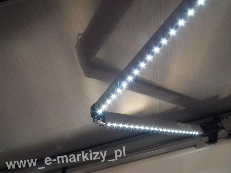 Punkty świetlne na taśmie ledowej oświetlenia do markiz zamocowanego do ramienia markizy o srebrnej konstrukcji