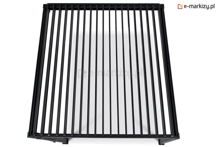 Widok z góry na dach pergoli bioklimatycznej Gloria w kolorze ciemnoantracytowym, przedstawiony na jasnym tle. Konstrukcja zadaszenia składa się z licznych, równolegle rozmieszczonych lameli aluminiowych, które znajdują się w pozycji całkowicie otwartej (pionowej). Taki układ odsłania regularne prześwity między lamelami, umożliwiając swobodny przepływ powietrza i światła przez płaszczyznę dachu. Lamele są osadzone w sztywnej, prostokątnej ramie o matowym wykończeniu, a w dolnej części grafiki widoczne są fragmenty mocowań słupów nośnych. Całość prezentuje techniczną precyzję mechanizmu obrotowego dachu lamelowego w nowoczesnej stylistyce.