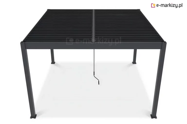 Zdjęcie przedstawia widok z podwyższonej perspektywy na zadaszenie wolnostojącej pergoli aluminiowej Marlo Duo w kolorze antracytowym. Fotografia eksponuje dwusekcyjną budowę dachu żaluzjowego, w którym dwa pola lameli są przedzielone środkową belką wzmacniającą. Aluminiowe lamele znajdują się w pozycji zamkniętej, tworząc jednolitą, płaską płaszczyznę osłaniającą przestrzeń pod pergolą. Widoczne są cztery podpory oraz szeroki profil ramy dachowej, w której ukryty jest system odprowadzania wody. W centralnym punkcie pod dachem widoczna jest pionowa korba służąca do manualnego sterowania mechanizmem obrotowym lameli. Produkt zaprezentowany jest na jednolitym białym tle, co podkreśla jego techniczną konstrukcję.