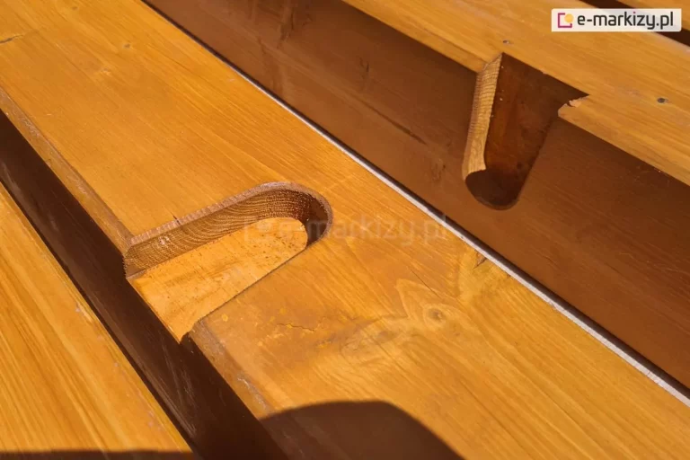 Belki drewnianej pergoli Koro pokrytej lakierobejcą z widocznymi nacięciami frezowymi, ułatwiającymi montaż krokwi dachowych.