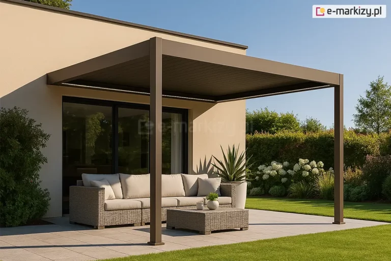Przyścienna pergolę lamelowa Marlo w matowym wykończeniu w kolorze taupe, zainstalowana na nowoczesnym tarasie. Konstrukcja zadaszenia opiera się na dwóch pionowych słupach o kwadratowym profilu, a jej tylna część jest zamontowana do jasnej, beżowej elewacji budynku. Lamele dachowe są całkowicie zamknięte, tworząc jednolitą, płaską powierzchnię chroniącą przed słońcem. Pod pergolą znajduje się strefa wypoczynkowa wyposażona w narożnik oraz stolik kawowy wykonany z technorattanu w szarym odcieniu, z jasnymi poduszkami siedziskowymi. Taras wyłożony jest dużymi, kwadratowymi płytami w kolorze jasnoszarym. Bezpośrednio przy meblach, w białej donicy, rośnie roślina o długich, ostrych liściach, a obok budynku widoczna jest gęsta zieleń ogrodowa. W tle rozpościera się zadbany trawnik, białe hortensje oraz pas wysokiego żywopłotu. Scena jest skąpana w naturalnym świetle dziennym, a na elewacji widoczne są wyraźne cienie rzucane przez konstrukcję pergoli i roślinność.