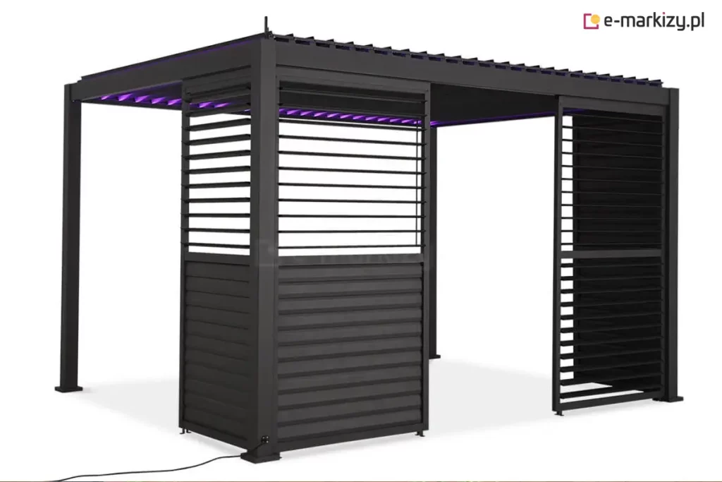 Antracytowa pergola ogrodowa Gloria z nowoczesnym systemem przesuwnych paneli żaluzjowych oraz zintegrowanym oświetleniem LED. Na zdjęciu widoczna jest konstrukcja z dachem lamelowym, którego lamele są częściowo otwarte i emitują intensywne, fioletowe światło skierowane do wnętrza pergoli. Zabudowa boczna składa się z dwóch modułów przesuwnych: lewy panel jest zamknięty i posiada dolną część z pełnymi lamelami oraz górną z lamelami ustawionymi poziomo, natomiast prawy panel jest odsunięty do krawędzi, odsłaniając szerokie przejście. Cały stelaż, ramy paneli oraz lamele dachowe wykończone są matowym lakierem w kolorze ciemnego antracytu. W dolnej części lewego słupa frontowego widoczne jest gniazdo zasilające z podłączonym czarnym przewodem elektrycznym, a stabilność konstrukcji zapewniają kwadratowe stopy montażowe przytwierdzone do podłoża.