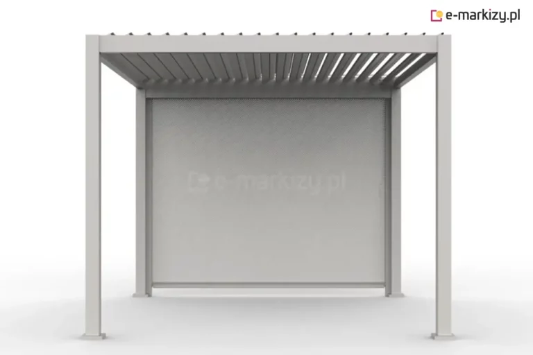 Biała pergola lamelowa Gloria z zamontowaną na tylnej ścianie materiałową roletą zewnętrzną typu screen. Konstrukcja posiada dach wykonany z ruchomych, aluminiowych lameli, które są ustawione pod kątem, wpuszczając rozproszone światło do wnętrza. Roleta w kolorze jasnoszarym jest całkowicie rozwinięta, zasłaniając pełną wysokość przejścia między dwoma tylnymi słupami i zapewniając ochronę przed słońcem oraz wiatrem. Cały stelaż, w tym cztery pionowe słupy z kwadratowymi stopami montażowymi, jest polakierowany na biało. Tkanina rolety posiada drobną, perforowaną strukturę, która ogranicza nagrzewanie, zachowując jednocześnie częściową przezierność. Pergola prezentowana jest na jednolitym, jasnym tle w widoku frontalnym.