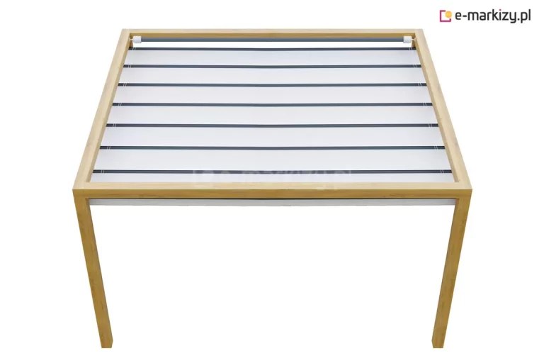 Drewniana pergola tarasowa o konstrukcji wykonanej z jasnego drewna świerkowego, zaprojektowana w formie prostokątnej ramy wspartej na czterech pionowych słupach. Wewnątrz górnej ramy zamontowano system zadaszenia typu rzymskiego, składający się z jasnego, naprężonego materiału, który jest podzielony poprzecznymi listwami wzmacniającymi na równe segmenty. Całość konstrukcji prezentuje się w ujęciu z góry pod kątem, ukazując przejrzysty i minimalistyczny design, który łączy naturalną strukturę drewna z funkcjonalnym, nowoczesnym systemem osłonowym dedykowanym do zacieniania przestrzeni wypoczynkowych na tarasach.