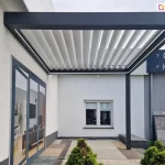 Konstrukcja pergoli tarasowej przyściennej w ustawieniu bocznym z panelami aluminiowymi dachu uchylonymi na prześwit