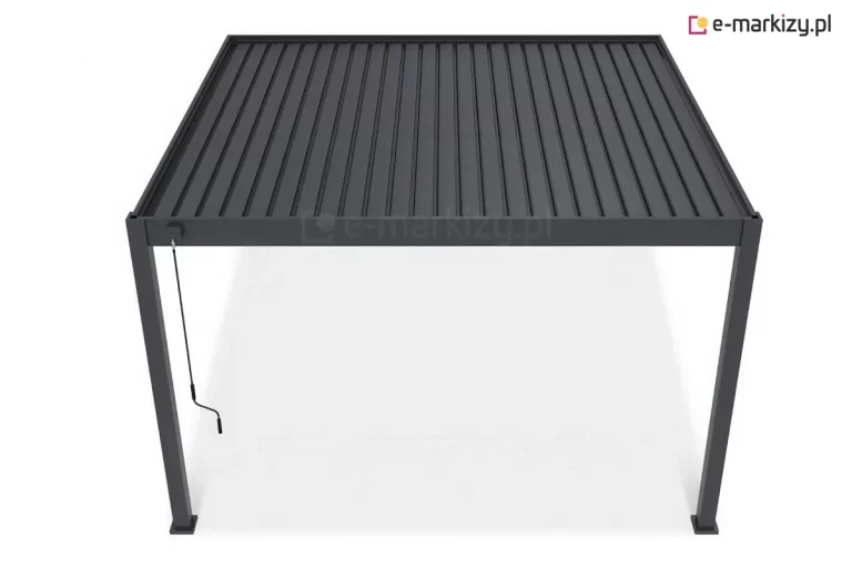 Nowoczesna pergola tarasowa z dachem lamelowym sterowanym ręcznie przedstawiona na jednolitym białym tle. Całość konstrukcji, obejmująca cztery pionowe słupy nośne oraz ramę zadaszenia, wykonana jest z aluminium w głębokim, matowym odcieniu ciemnej szarości lub antracytu. Zadaszenie składa się z równolegle ułożonych, podłużnych lameli, które tworzą szczelną, żebrowaną płaszczyznę dachową. Lamele są osadzone wewnątrz solidnej, prostokątnej ramy. Na przednim lewym słupie, tuż pod górną belką, zamontowany jest mechanizm sterujący w formie zwisającej, czarnej korby z rączką, służącej do manualnej regulacji kąta nachylenia piór dachu. Słupy wspierające mają kwadratowy przekrój i są zakończone u dołu płaskimi stopami montażowymi, które stabilizują konstrukcję na podłożu. Perspektywa ujęcia ukazuje produkt z lekkiego podwyższenia, co pozwala dokładnie przyjrzeć się strukturze zamkniętego dachu oraz proporcjom całej wolnostojącej budowli ogrodowej.