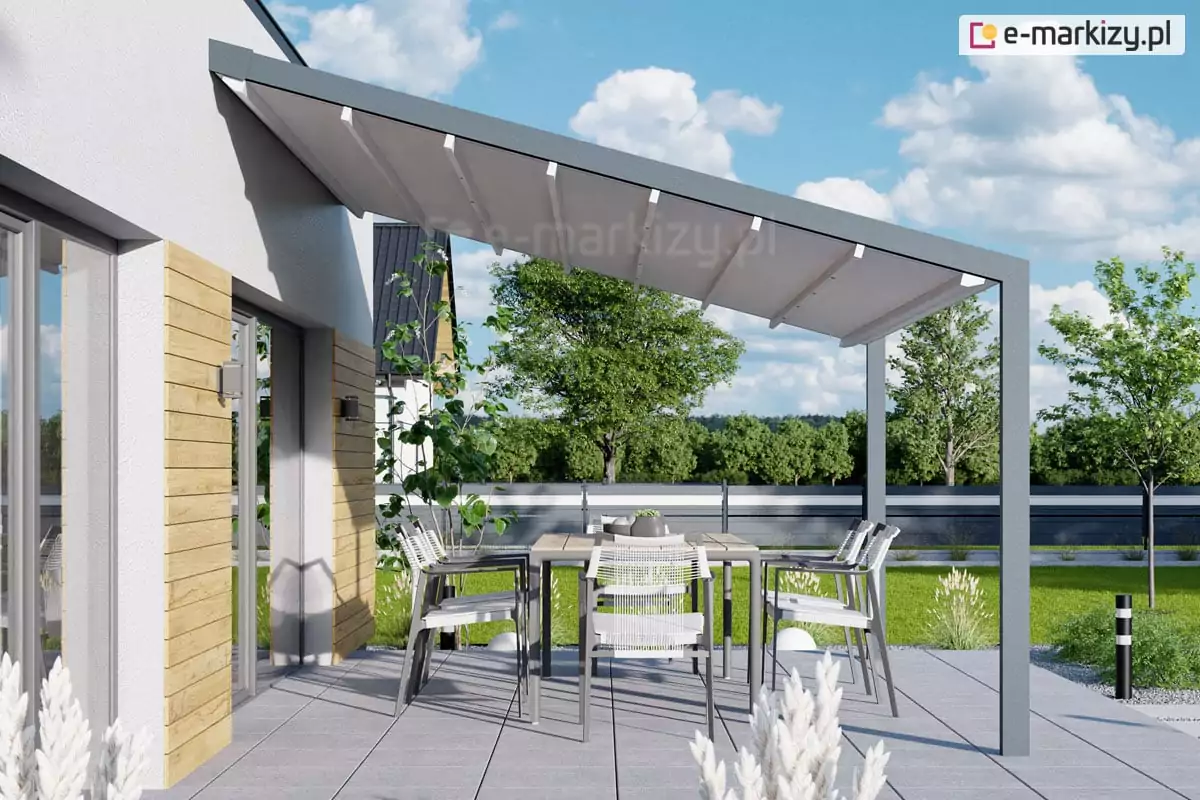 Wizualizacja nowoczesnego tarasu przy budynku mieszkalnym, na którym zainstalowana została pergola tarasowa przyścienna Tarasola Light. Konstrukcja pergoli składa się z ciemnoszarych, antracytowych profili aluminiowych, gdzie jedna strona systemu jest zakotwiczona bezpośrednio do elewacji budynku, a druga opiera się na dwóch pionowych kolumnach o kwadratowym przekroku. Zadaszenie stanowi jasny, biały lub kremowy materiał techniczny ułożony w charakterystyczne dla tego modelu fałdy, co wskazuje na system tkaninowy, rzymski, rozsuwany na aluminiowych prowadnicach pod lekkim skosem w celu odprowadzenia wody opadowej. Pod zadaszeniem znajduje się strefa wypoczynkowa z prostokątnym stołem jadalnianym o jasnym blacie, otoczonym czterema nowoczesnymi krzesłami ogrodowymi z białymi siedziskami i ciemnymi stelażami. Podłoże tarasu wyłożone jest dużymi, jasnoszarymi płytami betonowymi o gładkiej strukturze. Elewacja budynku jest biała, wykończona fragmentami dekoracyjnymi z jasnego drewna w formie poziomych paneli ściennych przy dużych przeszkleniach drzwi tarasowych. W tle widoczny jest zadbany ogród z zielonym trawnikiem, niskimi krzewami oraz drzewami liściastymi pod czystym, błękitnym niebem z rozproszonymi białymi chmurami. Całość aranżacji przedstawia minimalistyczny i funkcjonalny design zewnętrznej strefy relaksu, gdzie pergola Light tarasola pełni funkcję ochrony przed słońcem i deszczem.
