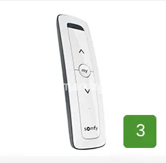 Bezprzewodowy pilot zdalnego sterowania marki Somfy o minimalistycznym designie, utrzymany w biało-szarej kolorystyce, służący do obsługi automatyki markizowej, wyposażony w przyciski sterujące kierunkiem ruchu oraz centralny przycisk z funkcją zaprogramowanej pozycji komfortowej my.