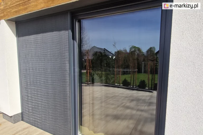 Moskitiera plisowana Zig Zag zamocowana we wnęce pozwala na przesłonięcie części okna, jednocześnie nie utrudnia przejścia z wnętrza na taras.
