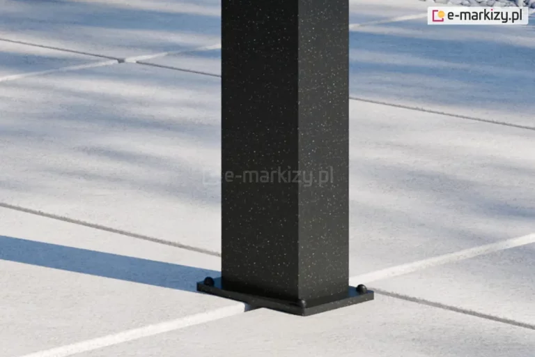 Prostokątna podpora zadaszenia tarasu Lunaro wykonana w kolorze antracytowym, zamocowana za pomocą śrub z nakładkami z pcv dużych płyt tarasowych w jasnoszarym odcieniu.