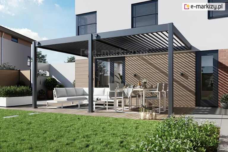 Wizualizacja nowoczesnej, dwumodułowej pergoli tarasowej z dachem lamelowym model Rubio Soft, zamontowanej przy elewacji nowoczesnego piętrowego domu o białej fasadzie. Konstrukcja pergoli jest wykonana z aluminium w kolorze antracytowym i opiera się na trzech pionowych słupach o kwadratowym przekroju, które są zakotwione w drewnianym tarasie. Zadaszenie składa się z dwóch sekcji ruchomych lameli – w lewym module lamele są mocno przymknięte, natomiast w prawym module są one otwarte, wpuszczając światło słoneczne i tworząc charakterystyczny wzór pasów światła i cienia na elewacji budynku. Przy lewym i środkowym słupie zamontowane są manualne korby do regulacji kąta nachylenia lameli. Pod pergolą znajduje się strefa wypoczynkowa z dużym, jasnym narożnikiem ogrodowym oraz strefa jadalniana z nowoczesnym stołem i sześcioma krzesłami w kolorze białym. Na stole widoczna jest zastawa, a obok stoją dekoracyjne lampiony. W tle widać fragment zielonego trawnika, niskie nasadzenia w białych donicach oraz nowoczesne ogrodzenie. Elewacja parteru pod pergolą wykończona jest poziomymi deskami w naturalnym odcieniu drewna, z zamontowanymi czarnymi kinkietami zewnętrznymi. Duże przeszklenia i drzwi tarasowe w ciemnych ramach prowadzą do wnętrza budynku.