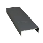 Profil maskujący typu U do systemu przesuwnego Auris w wersji 6-torowej, wykonany z aluminium lakierowanego proszkowo na kolor antracytowy. Element posiada formę szerokiego, odwróconego ceownika o gładkiej i matowej powierzchni, zaprojektowanego do estetycznego wykończenia górnej lub bocznej części wielotorowej prowadnicy. Konstrukcja charakteryzuje się cienkimi, precyzyjnie dociętymi ściankami oraz szeroką płaszczyzną górną, która skutecznie zakrywa mechanizmy jezdne. Na zdjęciu profil zaprezentowany jest w ujęciu perspektywicznym, co pozwala uwidocznienie jego znacznej szerokości dopasowanej do systemu sześciu skrzydeł oraz czyste, surowe krawędzie przekroju poprzecznego.