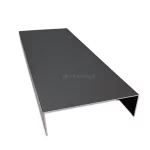 Profil maskujący typu U dedykowany do systemu przesuwnego Auris w wersji 7-torowej, wykonany z trwałego aluminium lakierowanego na kolor antracytowy. Element posiada formę bardzo szerokiego, odwróconego ceownika o gładkiej, matowej powierzchni, zaprojektowanego do estetycznej zabudowy bocznej lub górnej prowadnicy siedmiotorowej. Konstrukcja charakteryzuje się dużą szerokością płaszczyzny kryjącej oraz precyzyjnie uformowanymi ściankami bocznymi, co pozwala na pełne zamaskowanie mechanizmów jezdnych przy rozbudowanych konfiguracjach skrzydeł. Na zdjęciu profil ukazany jest w ujęciu perspektywicznym na jasnym tle, prezentując jednolity, ciemnoszary odcień oraz czysty przekrój poprzeczny komponentu.