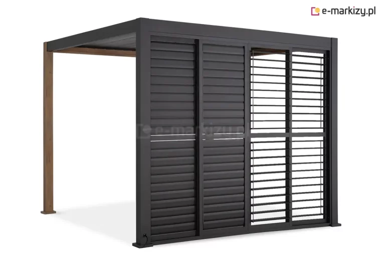 Antracytowa pergola Gloria z systemem przesuwnych paneli żaluzjowych, przedstawiona w ujęciu od strony frontu. Zabudowa składa się z czterech skrzydeł, które są przesunięte w prawą stronę, pozostawiając lewą część boku pergoli otwartą. Dwa panele po lewej stronie mają lamele ustawione w pozycji całkowicie zamkniętej, tworząc jednolitą osłonę. Dwa panele po prawej stronie mają lamele ustawione poziomo, co pozwala na swobodny przepływ światła i wgląd do wnętrza. Każde skrzydło posiada aluminiową ramę z poprzeczką dzielącą panel na dwie równe sekcje pionowe. Konstrukcja pergoli opiera się na ciemnych słupach przednich oraz tylnych słupach o strukturze imitującej drewno. W dolnej części lewego słupa widoczne jest gniazdo z podłączonym przewodem zasilającym.