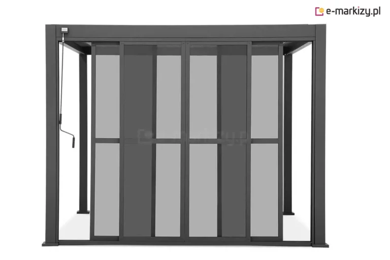 Antracytowa pergola ogrodowa Gloria wyposażona w system przesuwnych drzwi poliwęglanowych w pozycji półotwartej. Na zdjęciu widoczne są cztery wąskie panele drzwiowe, z których dwa środkowe zostały rozsunięte na boki, częściowo nakładając się na panele skrajne. Każde skrzydło posiada aluminiową ramę w kolorze ciemnoantracytowym z poziomą poprzeczką wzmacniającą w połowie wysokości oraz wypełnienie z przyciemnianego, szarego poliwęglanu. Po lewej stronie górnej belki zamontowany jest mechanizm korbowy z drążkiem do sterowania zadaszeniem. Przez przezierne panele oraz centralny otwór widoczne są tylne słupy konstrukcyjne pergoli, a całość osadzona jest na stabilnych, kwadratowych stopach montażowych na jasnym tle.