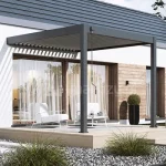 Pergola Marlo z korbą ręczną do obracania lameli zamocowana do budynku na drewnianym tarasie