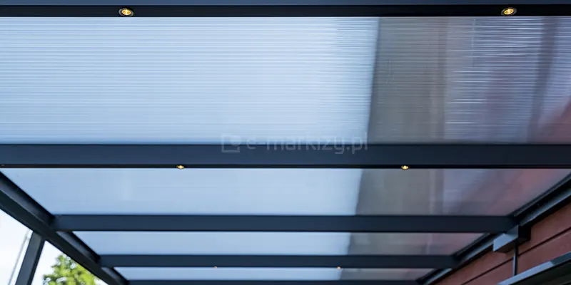 Zadaszenie tarasu Bosco Lunaro Deponti z konstrukcja w kolorze antracytowym z zainstalowanymi w belkach dachowych punktowymi światłami LED.