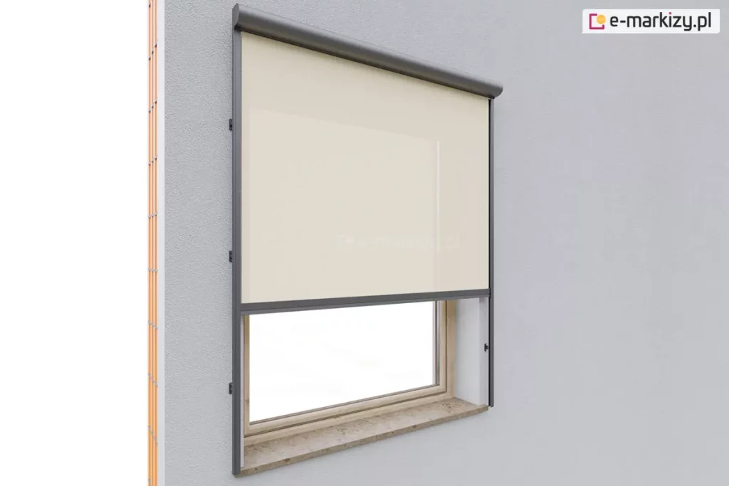 Zbliżenie na elewację budynku w jasnoszarym kolorze, z zamontowaną na oknie o drewnianej ramie zewnętrzną osłoną typu Refleksol 90 Selt z tkaniną screen. Roleta z jasną, beżową tkaniną przeciwsłoneczną została częściowo rozwinięta i przysłania górną część okna osadzonego w szarej elewacji. Zastosowano prowadnice boczne, zamocowane do ściany poza wnęką okienną, które stabilizują tkaninę i zapewniają odporność na wiatr, a całość zamknięta jest w estetycznej kasecie o zaokrąglonym profilu, umieszczonej w górnej części nad wnęką okienną. Rama prowadnic oraz kaseta mają grafitowy kolor, co kontrastuje z jasną powierzchnią elewacji i podkreśla nowoczesny charakter rozwiązania. Osłona Refleksol pełni tutaj funkcję ochrony przeciwsłonecznej, a jej subtelny wygląd sprawia, że integruje się wizualnie z bryłą budynku.