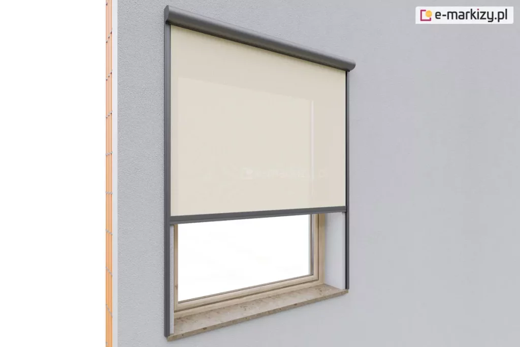 Obraz przedstawia montaż zewnętrznej rolety Refleksol 90 Selt z tkaniną screenową w jasnym kolorze na pojedynczym oknie w elewacji wykończonej szarym tynkiem. Osłona znajduje się w wąskiej kasecie aluminiowej w kolorze grafitowym, która nadaje całości nowoczesny i elegancki wygląd. Tkanina screenowa, wykonana z materiału o drobnym splocie, została rozwinięta do połowy wysokości okna, co pozwala na kontrolę nasłonecznienia bez całkowitego ograniczenia widoku na zewnątrz. Dolna belka rolety jest dopasowana kolorystycznie do prowadnic bocznych i utrzymuje materiał w napięciu, dzięki jej prowadzeniu w bocznych prowadnicach, zamocowanych bezpośrednio do ściany elewacji poza wnęką okienną.