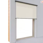 Fragment elewacji budynku widocznej w przekroju z ukazaniem warstwy cegiel oraz tynku, z zamontowaną na dużym oknie o drewnianej ramie zewnętrzną osłoną Refleksol 90 Selt. Roleta z jasną, beżową tkaniną przeciwsłoneczną została częściowo rozwinięta i przysłania górną część okna osadzonego w szarej elewacji. Zastosowano prowadnice boczne linkowe, przymocowane za pomocą napinaczy do podłogi, które stabilizują tkaninę. Całość zamknięta jest w estetycznej kasecie o zaokrąglonym profilu, umieszczonej w górnej części nad wnęką okienną.