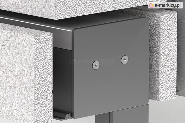 Zbliżenie techniczne na montaż podtynkowy kasety refleksola 120 Ziiip Selt w warstwie termoizolacji budynku. Zdjęcie prezentuje boczną pokrywę (boczek) kasety w kolorze antracytowym, przymocowaną dwiema śrubami z gniazdem typu torx. Kaseta jest precyzyjnie osadzona w wycięciu wykonanym w białym styropianie o wyraźnej strukturze granulatu. Konstrukcja ukazuje sposób integracji systemu osłonowego z elewacją, gdzie górna i boczna część obudowy stykają się bezpośrednio z materiałem izolacyjnym, co pozwala na późniejsze ukrycie mechanizmu pod tynkiem. W dolnej części widoczny jest profil prowadnicy.