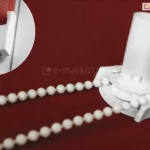 Umieszczony na czerwonym tle mechanizm łańcuszkowy rolety mini w kolorze białym. W lewym górnym rogu w okrągłej ramce zbliżenie belki dolnej, obciążnika tkaniny rolety mini.