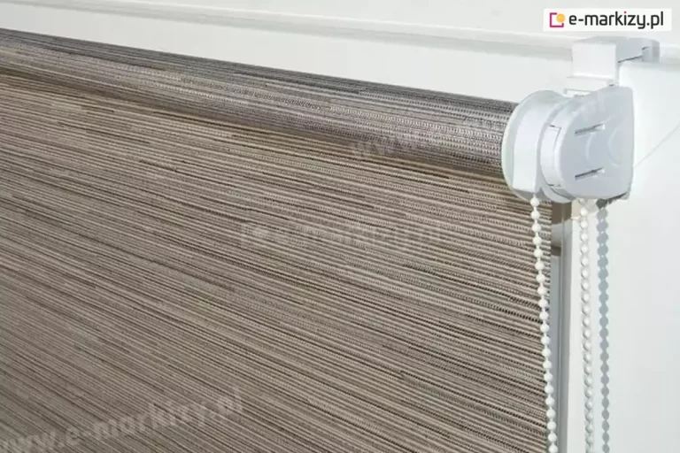 Roletka mini bez kasety i prowadnic z tkaniną z kolekcji Lines w delikatne wąskie paski w różnych odcieniach brązu i beżu, zamocowana na białym skrzydle okna za pomocą białych uchwytów bezinwazyjnych. Roleta wyposażona w biały mechanizm oraz łańcuszek do sterowania.